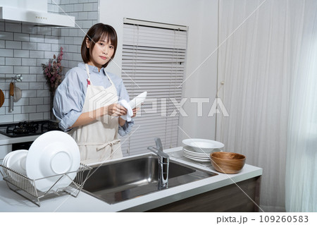 台所で皿を拭く女性 台所で皿を拭く女性 109260583
