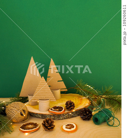 A creative handmade little Christmas tree of cardboard on green backround. eco-friendly and zero waste concept A creative handmade little Christmas tree of cardboard on green backround. eco-friendly and zero waste concept 109260611