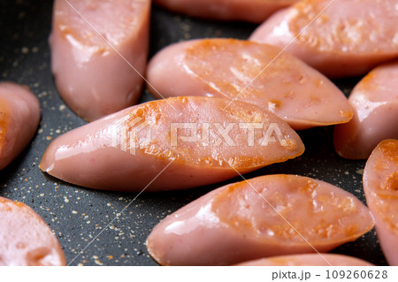 魚肉ソーセージ(斜め切り)をフライパンで炒める調理シーン。 魚肉ソーセージ(斜め切り)をフライパンで炒める調理シーン。 109260628