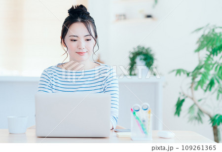 リビングでノートパソコンを使う若い女性。 109261365