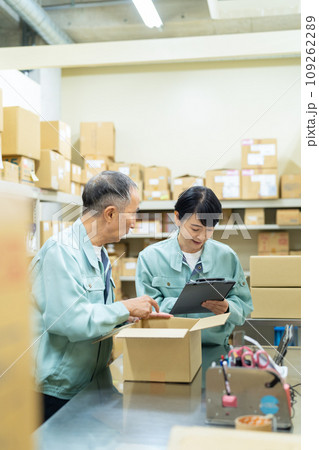 倉庫で梱包するミドルの男女の作業員 109262289