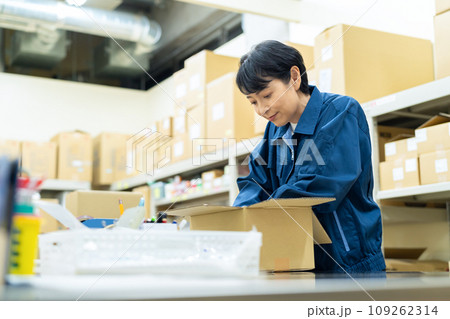 倉庫で梱包するミドルの女性の作業員 109262314