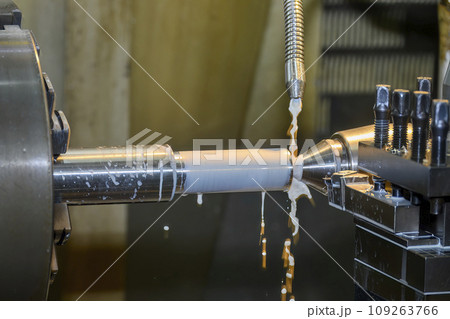 The lathe machine finish cut  metal shaft parts with liquid coolant method. 109263766