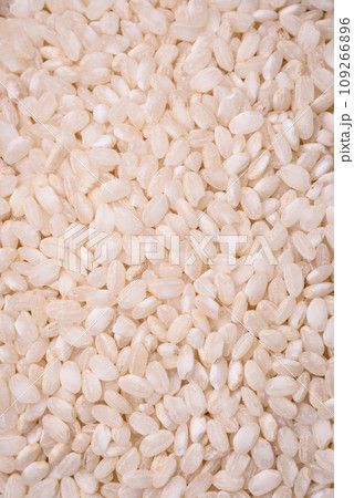 White uncooked rice in a round ceramic bowl on a dark concrete background 109266896