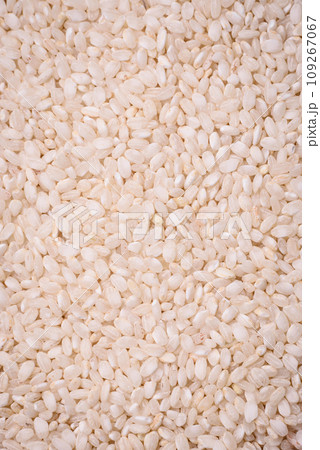 White uncooked rice in a round ceramic bowl on a dark concrete background 109267067