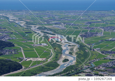獅子吼高原から飛ぶパラグライダーと金沢平野 手取川扇状地の眺め 109267166