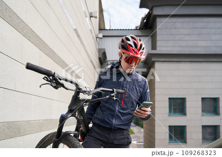 Man carries a bicycle on his shoulder while climbing the stairs in the city. 109268323