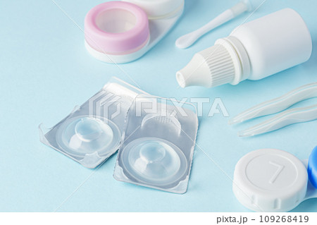Contact lenses and accessories with solution on blue background 109268419