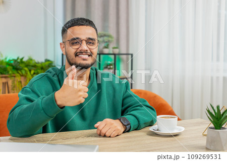 Happy Indian young man looking approvingly at camera show thumbs up like positive sign good news 109269531