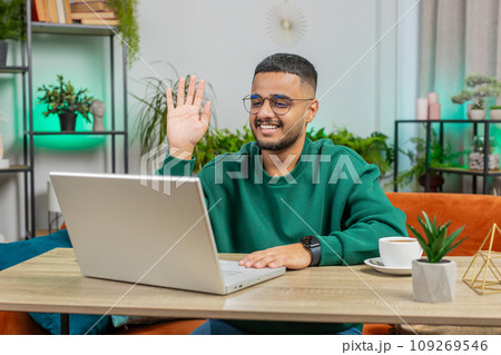 Man sitting on home couch, looking at camera, making video conference call with friends or family 109269546