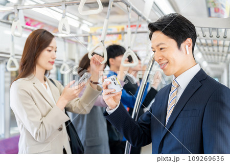 通勤電車でスマホを見るミドルのビジネスマン　撮影協力「京王電鉄株式会社」 109269636
