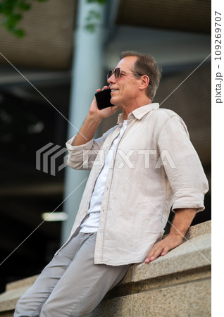 Man posing on street and looking talking by his phone. Man posing on street and looking talking by his phone. 109269707
