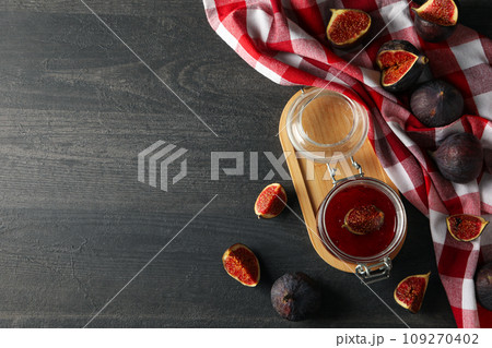 Figs, jars of jam and towel on gray background, space for text Figs, jars of jam and towel on gray background, space for text 109270402