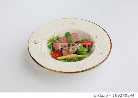 Tuna steak, lettuce and vegetables in a beautiful plate on a white background, restaurant serving 109270544
