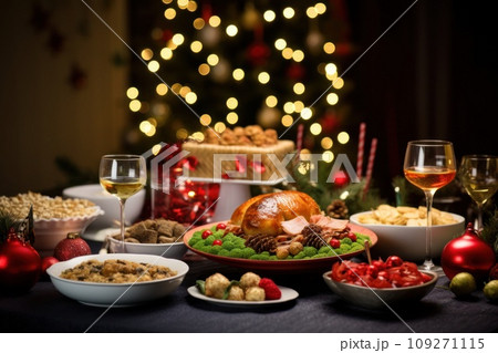 Christmas festive family dinner served different dishes and salads, many snacks, sparkling wine and glasses. New Year's decor with Xmas tree on background. Christmas festive family dinner served different dishes and salads, many snacks, sparkling wine and glasses. New Year's decor with Xmas tree on background. 109271115