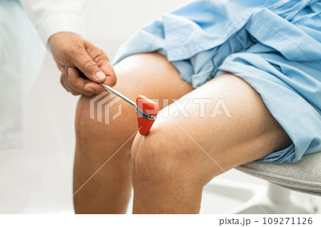 Asian doctor use hammer knock senior woman patient to check knee reflex, nerve and muscle in hospital. Asian doctor use hammer knock senior woman patient to check knee reflex, nerve and muscle in hospital. 109271126