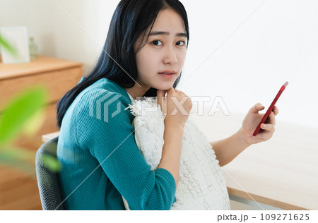 スマートフォンを持って考える若い女性 スマートフォンを持って考える若い女性 109271625