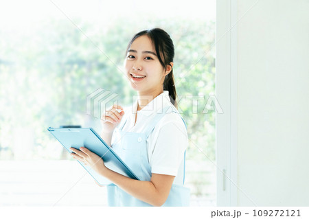 窓際に立つ介護士の若い女性 109272121
