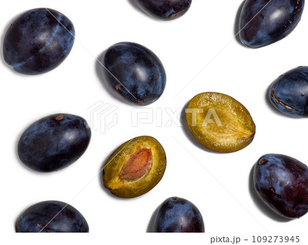 Plums on a white background. Juicy sliced plum. Stone in yellow pulp. Healthy food concept. Sweet purple variety. Fruit on the table. 109273945