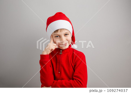 Cheerful boy in Santa hat on isolated gray background showing different funny emotions, surprise, joy, delight. 109274037