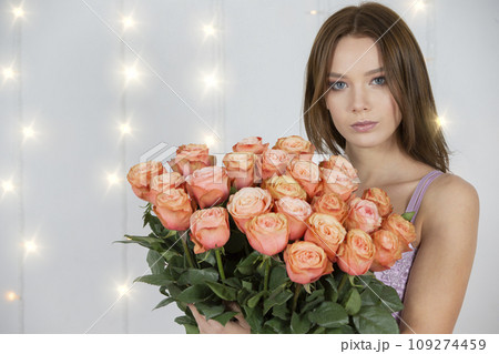 Portrait of a young beautiful girl with a bouquet of roses Portrait of a young beautiful girl with a bouquet of roses 109274459