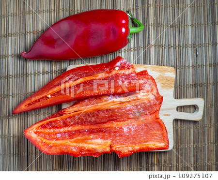 The pulp of long red sweet pepper on the kitchen table. Cut pepper. Preparation of salad. Vegetable as an ingredient. Kleschatka. Cut red juicy vegetable. Without seeds. The pulp of long red sweet pepper on the kitchen table. Cut pepper. Preparation of salad. Vegetable as an ingredient. Kleschatka. Cut red juicy vegetable. Without seeds. 109275107