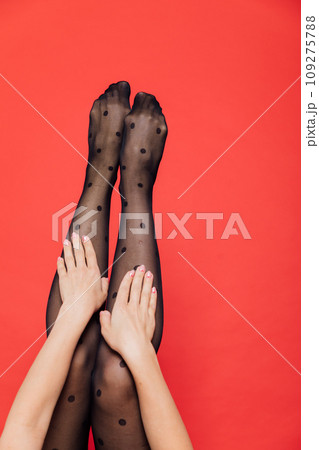 Beautiful slender female legs in black pantyhose stockings as background 109275788