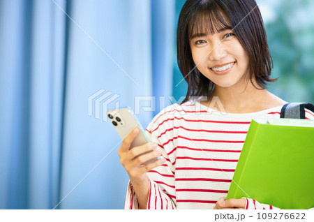 スマホを見る女子大生 撮影協力：有明教育芸術短期大学 109276622