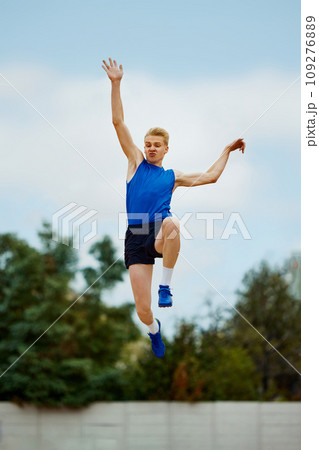 leap of determination frozen in this captivating long jump photo. motivated young man, professional sportsman doing perfect jump. 109276889