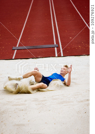 Sand landing after a well-executed jump. Professional sportsman, athletic man training long jumps to send before championship 109276921