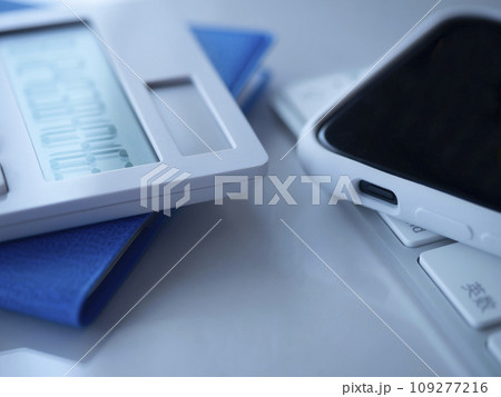テーブルに置かれた手帳とキーボードとスマートフォンと電卓 109277216
