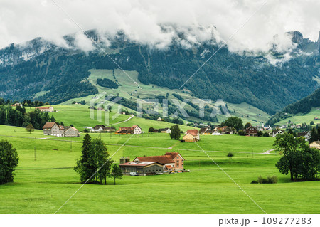 Small village on green hill among Swiss Alps in summer at Switzerland Small village on green hill among Swiss Alps in summer at Switzerland 109277283