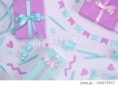 white background with candles, gift boxes, serpentine and holiday decorations in blue and lilac colors for birthday or party celebration, birthday, anniversary, congratulations concept.  109277657