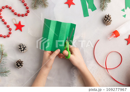 Christmas wreath from color paper with children. Step by step instructions. Handmade DIY new year Christmas wreath from color paper with children. Step by step instructions. Handmade DIY new year 109277967