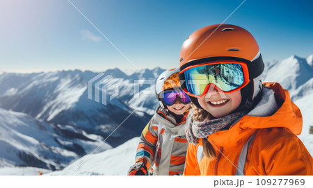 Portrait of a happy, smiling children snowboarder against the backdrop of snow-capped mountains at a ski resort, during the winter holidays. 109277969