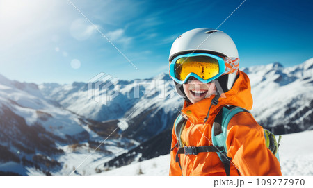 Portrait of a happy, smiling child snowboarder against the backdrop of snow-capped mountains at a ski resort, during the winter holidays. 109277970