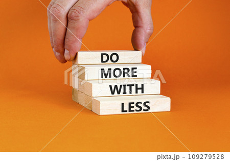 Do more with less symbol. Concept word Do more with less on beautiful wooden block. Beautiful orange table orange background. Businessman hand. Business do more with less concept. Copy space. Do more with less symbol. Concept word Do more with less on beautiful wooden block. Beautiful orange table orange background. Businessman hand. Business do more with less concept. Copy space. 109279528