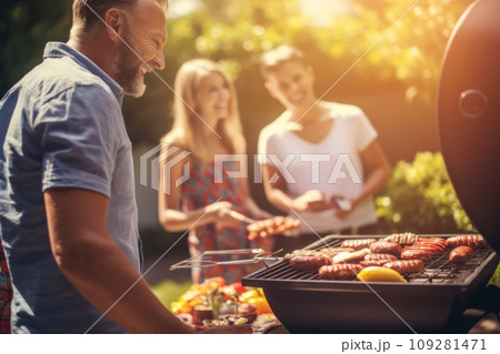 A group of people together at a bbq. Family and friends having picnic barbeque grill in garden. having fun eating and enjoying time. sunny day in the summer. blur background. A group of people together at a bbq. Family and friends having picnic barbeque grill in garden. having fun eating and enjoying time. sunny day in the summer. blur background. 109281471