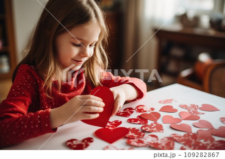 Kid making heart-shaped Valentine's card 109282867
