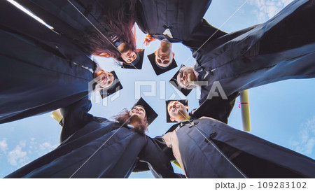 College students stand in a circle wearing black robes. College students stand in a circle wearing black robes. 109283102