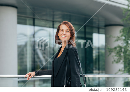 Smiling businesswoman with ginger hair looking away while standing outdoors	 109283148