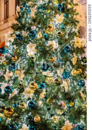 Christmas tree sparkling with colorful illumination stands near the building Christmas tree sparkling with colorful illumination stands near the building 109285059