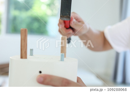 Man assembling furniture at home Man assembling furniture at home 109288068
