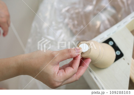 Man sticking floor care pad at sofa leg 109288103