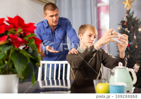 Father is unhappy with his son and expresses his displeasure during holiday of christmas Father is unhappy with his son and expresses his displeasure during holiday of christmas 109288868