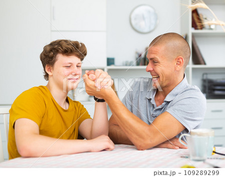 Father and his son doing arm wrestling Father and his son doing arm wrestling 109289299