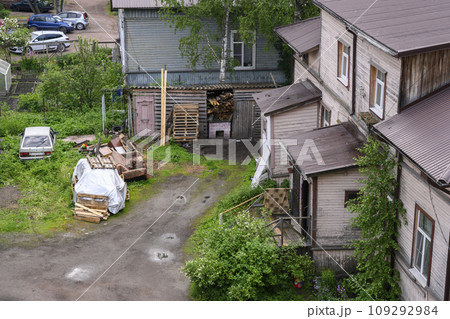 Backyard of a street with wooden houses, sheds and trees in the town of Sortavala in Karelia Backyard of a street with wooden houses, sheds and trees in the town of Sortavala in Karelia 109292984