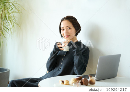 お茶を飲みながらパソコン作業する女性 お茶を飲みながらパソコン作業する女性 109294217