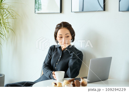 お茶を飲みながらパソコン作業する女性 109294229