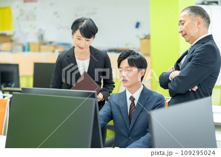 オフィスで打ち合わせをする新入社員と管理職の男女のビジネスマン オフィスで打ち合わせをする新入社員と管理職の男女のビジネスマン 109295024